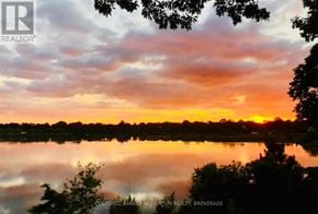 St. Catharines (Port Dalhousie) apartment for rent - A serene landscape with a sunset and a lake.