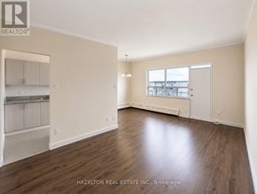 Toronto (Parkwoods-Donalda) condo for rent - A spacious room with wood flooring and a large window.