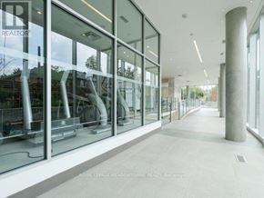Toronto (Woodbine Corridor) condo for rent - A long hallway with glass doors and a white floor.