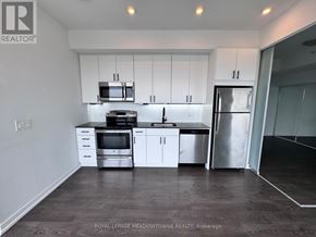 Toronto (Woodbine Corridor) condo for rent - A kitchen with white cabinets and stainless steel appliances.