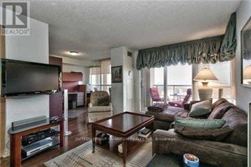 Mississauga (City Centre) condo for rent - A living room with a brown couch and a wooden coffee table.