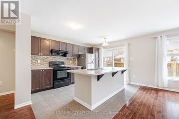 Milton (Wi Willmott) townhouse for rent - A kitchen with a black stove top oven and wooden cabinets.