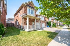 Milton (Wi Willmott) townhouse for rent - A brick house with a porch and a tree in front.