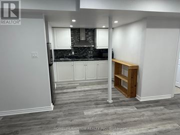 Vaughan (Maple) apartment for rent - A kitchen with white cabinets and a wooden shelf.
