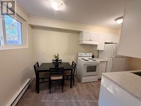 Peterborough (Town Ward 3) apartment for rent - A kitchen with a table and chairs in the foreground and a refrigerator, oven, and microwave in the background.