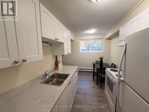Peterborough (Town Ward 3) apartment for rent - A kitchen with white cabinets and a sink.