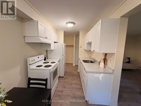 Peterborough (Town Ward 3) apartment for rent - A kitchen with white appliances and cabinets.