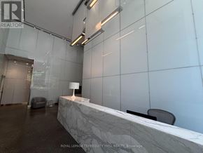 Toronto (Moss Park) condo for rent - A reception area with a marble counter and chairs.
