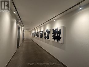 Toronto (Moss Park) condo for rent - A hallway with a series of black and white paintings on the wall.