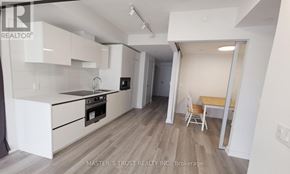 Toronto (Kensington-Chinatown) condo for rent - A kitchen with white cabinets and a wooden floor.