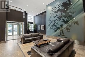 Toronto (Niagara) condo for rent - A living room with a glass wall and a leather couch.