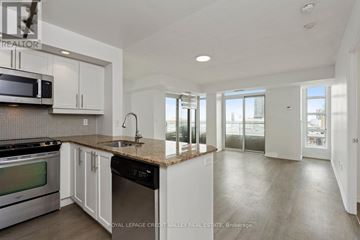 Toronto (Niagara) condo for rent - A kitchen with white cabinets and a granite countertop.