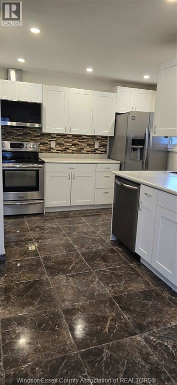 Windsor apartment for rent - A kitchen with white cabinets and a black stove top oven.