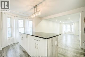 Windsor apartment for rent - A spacious kitchen with white cabinets and a black countertop.