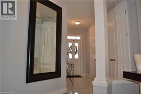 Kitchener apartment for rent - A hallway with a mirror on the wall and a door on the right.