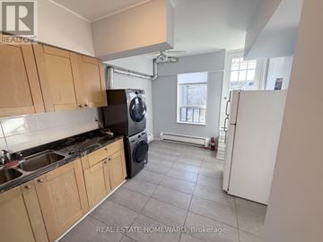 Toronto (North Riverdale) apartment for rent - A kitchen with wooden cabinets and a black dishwasher.