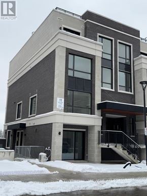 Richmond Hill (Devonsleigh) condo for rent - A grey and black building with a white sign that says 11 on it.