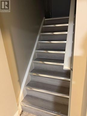 Brampton (Bram West) apartment for rent - A staircase with a metal railing and wooden steps.