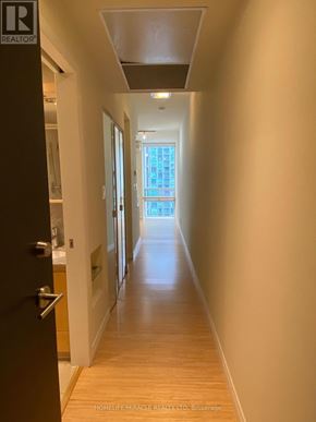 Mississauga (Fairview) condo for rent - A long hallway with a door on the left and a window on the right.