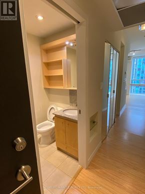Mississauga (Fairview) condo for rent - A bathroom with a toilet, sink and wooden shelves.