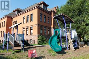 Hamilton (Stinson) condo for rent - A playground with a green slide and a red shopping cart in the foreground.