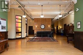 Hamilton (Stinson) condo for rent - A large room with a rug in the middle and a clock on the wall.