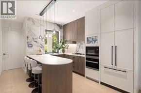 Vancouver apartment for rent - A modern kitchen with a large island and white cabinets.