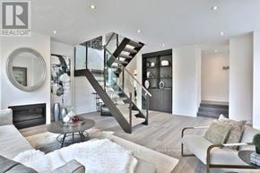 Toronto (Rosedale-Moore Park) townhouse for rent - A modern living room with a glass staircase and a fireplace.