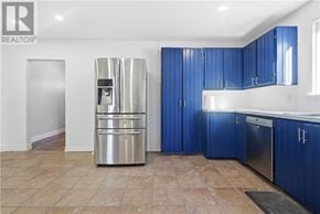 Azilda apartment for rent - A kitchen with blue cabinets and a stainless steel refrigerator.