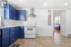 Azilda apartment for rent - A kitchen with blue cabinets and a white stove top oven.