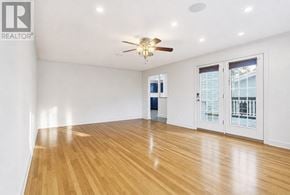 Azilda apartment for rent - A spacious room with wooden floors and a ceiling fan.
