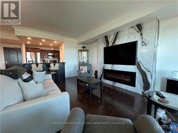 Ottawa condo for rent - A living room with a grey couch and a fireplace.