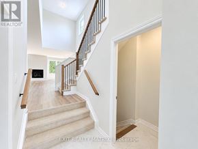 Russell townhouse for rent - A staircase with a wooden handrail and beige carpeted steps leads to a landing with a flat screen TV.
