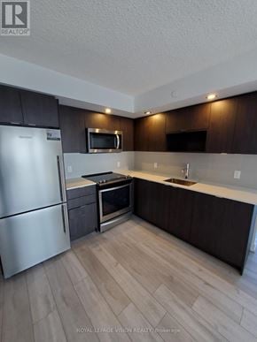 Toronto (Agincourt South-Malvern West) condo for rent - A kitchen with a refrigerator, microwave, oven, and sink.