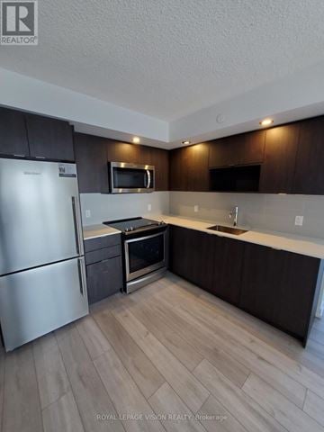 Toronto (Agincourt South-Malvern West) condo for rent - A kitchen with a refrigerator, microwave, oven, and sink.