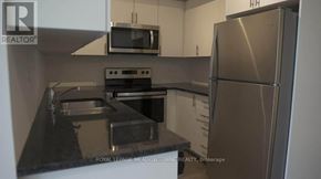 Toronto (Rouge) townhouse for rent - A kitchen with a stainless steel refrigerator, microwave, and oven.