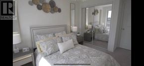 Toronto (Rouge) townhouse for rent - A bedroom with a bed, nightstand, and mirror.