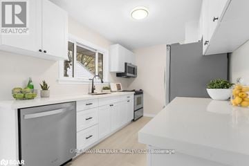 Orillia apartment for rent - A modern kitchen with white cabinets and appliances.