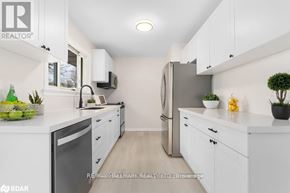 Orillia apartment for rent - A white kitchen with a refrigerator, microwave, and oven.