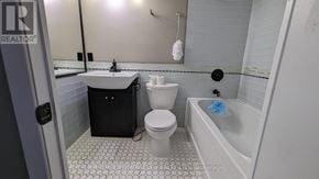 St. Catharines (Glendale/Glenridge) condo for rent - A bathroom with a white toilet, sink, and bathtub.