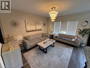 Cambridge townhouse for rent - A living room with a grey couch, a coffee table, and a chandelier.