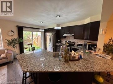 Cambridge townhouse for rent - A kitchen with granite countertops and a dining area with a table and chairs.