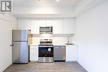 St. Catharines (E. Chester) townhouse for rent - A kitchen with white cabinets and a stainless steel refrigerator.
