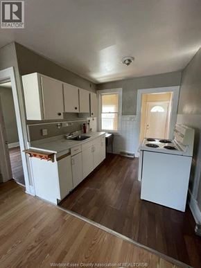 Windsor apartment for rent - A kitchen with white cabinets and a wooden floor.
