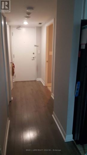 Toronto (Waterfront Communities) condo for rent - A hallway with wood floors and white walls.