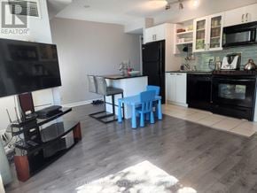 Toronto (Waterfront Communities) condo for rent - A modern kitchen with a black fridge and black countertops.