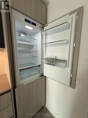 Toronto (Waterfront Communities) condo for rent - A modern kitchen with a refrigerator that has its door open.