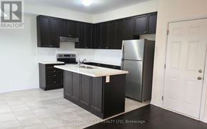 Innisfil apartment for rent - A kitchen with black cabinets and a white countertop.