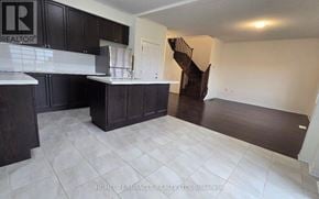 Innisfil apartment for rent - A kitchen with dark wood cabinets and a white tile floor.