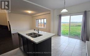Innisfil apartment for rent - A kitchen with a sink and a window overlooking a field.